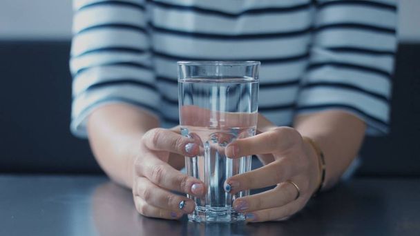 Close-up van dames hand met glas water - Foto, afbeelding