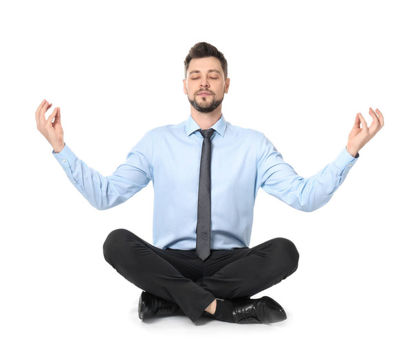 Young businessman meditating on white background - Photo, Image