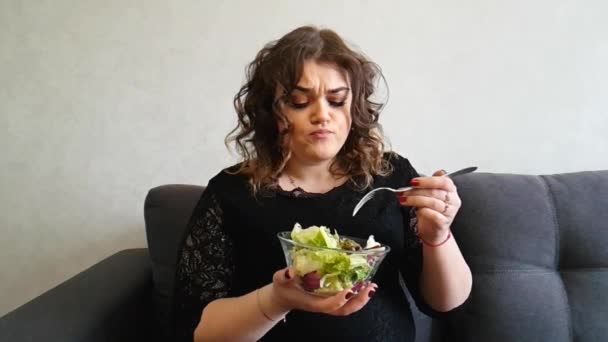 mooi full-length meisje zit op de Bank met een salade - Video