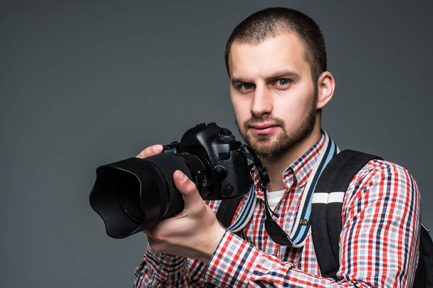 Portrait of male photographer with professional camera isolated on gray background - Photo, Image