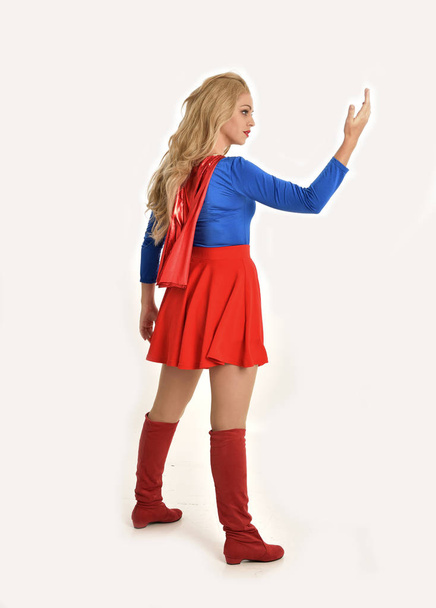 портрет красивої дівчини в костюмі супергероя, стояча поза, ізольована на білому фоні студії
. - Фото, зображення