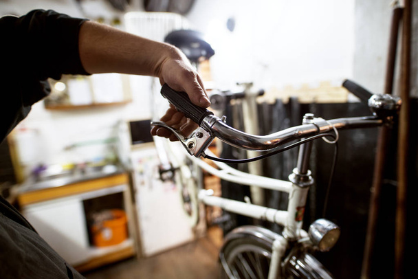 hombre comprobación de roturas de bicicleta en taller
  - Foto, imagen
