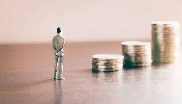 Мініатюрні люди дивляться майбутнє зі стоп-монетами про фінансову
  - Фото, зображення