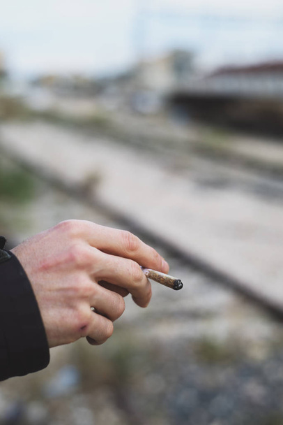 ο άνθρωπος που καπνίζει ένα τσιγάρο χέρι έλασης ή μια κοινή - Φωτογραφία, εικόνα