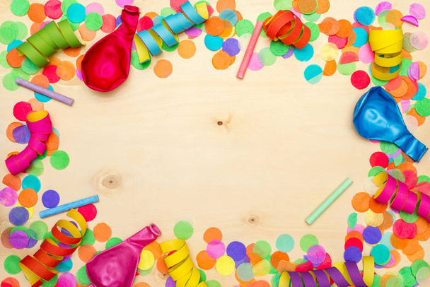 Colorful confetti and streamer on wooden background from above - Foto, imagen