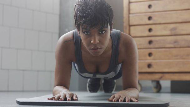 mujer en forma y tono joven haciendo ejercicio de fitness con elementos de tablón para abdominales fuertes en el loft soleado
 - Foto, Imagen