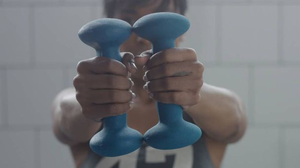 nero donna ritratto durante allenamento con i pesi primo piano con foucus a portata di mano con il peso
 - Foto, immagini