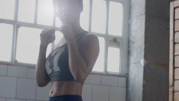 jong gemengd ras african american vrouw maakt een workout boksen in zonnige loft - Foto, afbeelding