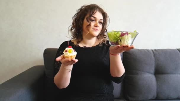 όμορφο κορίτσι γεμάτο με πίτες στον καναπέ - Πλάνα, βίντεο