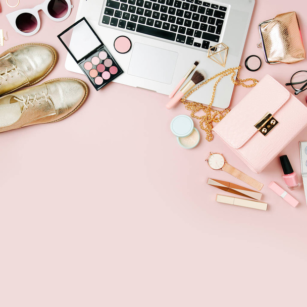 Fashion blogger workspace with laptop and female accessory, cosmetics products on pale pink table. flat lay, top view - Fotografie, Obrázek