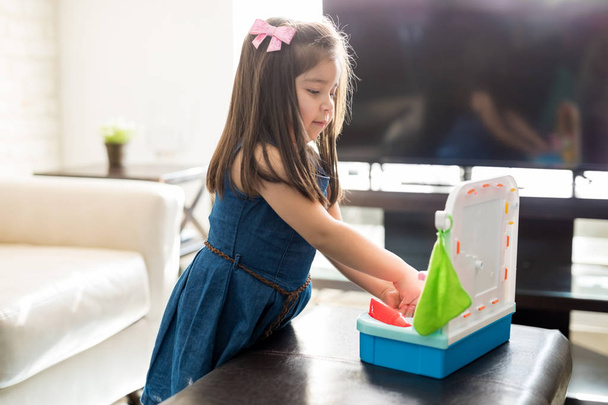 Latin kislány kézmosás játék kézi mosás mosogató otthon a nappaliban - Fotó, kép