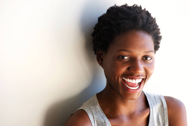 Közelről portré, szép fiatal afrikai nő, nevető fehér fal  - Fotó, kép