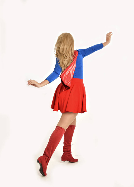 Ganzkörperporträt eines hübschen Mädchens im Superheldenkostüm, stehend, isoliert auf weißem Studiohintergrund. - Foto, Bild