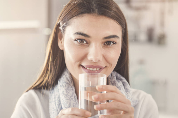 Νεαρή γυναίκα με ένα ποτήρι καθαρό νερό - Φωτογραφία, εικόνα