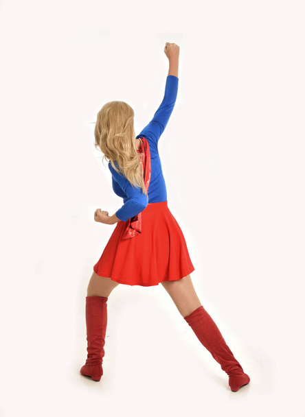 Ganzkörperporträt eines hübschen Mädchens im Superheldenkostüm, stehend, isoliert auf weißem Studiohintergrund. - Foto, Bild
