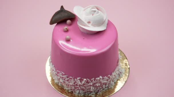 helle und bunte Torte in Großaufnahme auf rosa Hintergrund. Drehende Ansicht von oben. - Filmmaterial, Video