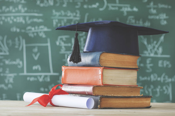 Verem könyveket diplomás hat előtt zöld chalkboard - Fotó, kép