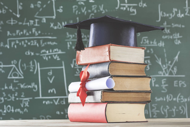 Verem könyveket diplomás kalap és a diploma előtt zöld chalkboard - Fotó, kép
