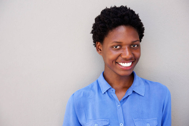 Крупним планом портрет привабливої молодої африканки, яка посміхається на сірому фоні
 - Фото, зображення