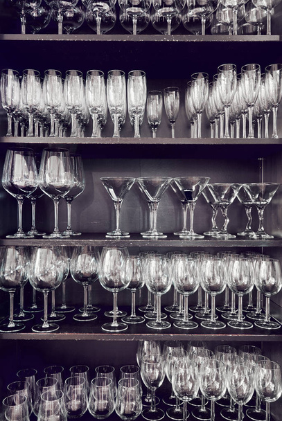 Variety of empty crystal glasses on a shelves - Fotó, kép