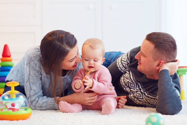 young mother and father playing together with infant baby girl, family games - Fotó, kép