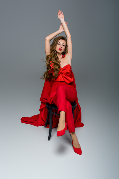 seductive woman posing in red clothes, on grey - Foto, immagini