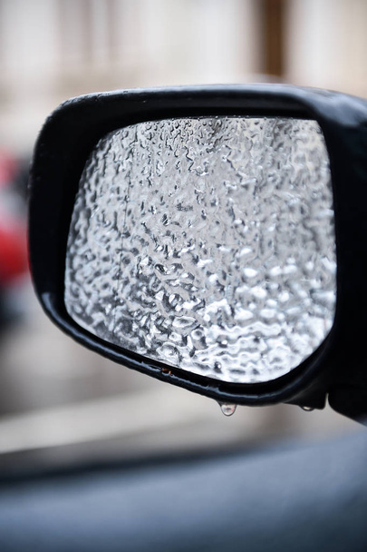 Vehicle mirror covered in ice during freezing rain - 写真・画像