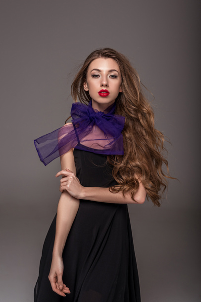 beautiful girl with long hair posing in purple scarf, isolated on grey - Фото, зображення