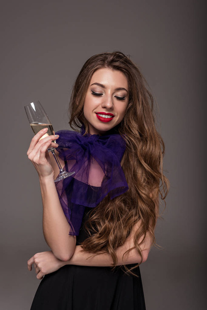beautiful girl posing with champagne glass for fashion shoot, isolated on grey - Фото, изображение