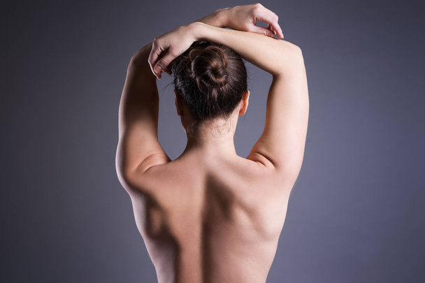 Slim topless woman on gray background, beauty female back - Фото, изображение