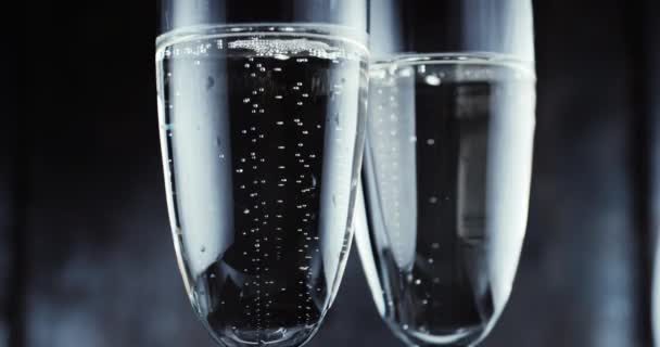 Vasos con burbujas de champán sobre fondo oscuro
 - Imágenes, Vídeo