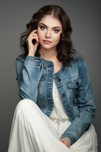 Portrait of a beautiful brunette woman in ��jeans jacket. - Fotó, kép