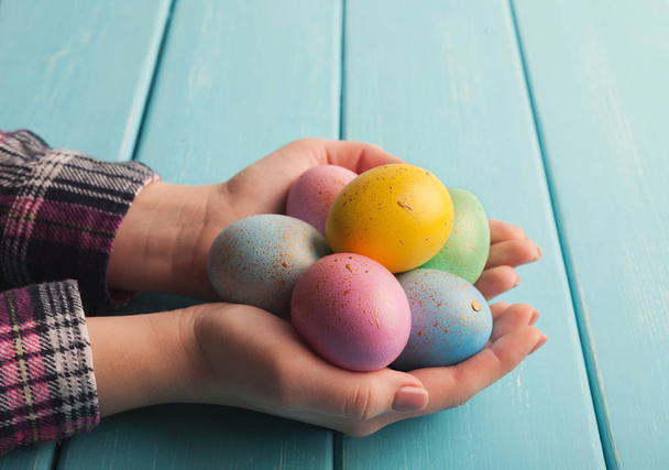 Woman holding colorful easter eggs on wooden planks - Фото, зображення