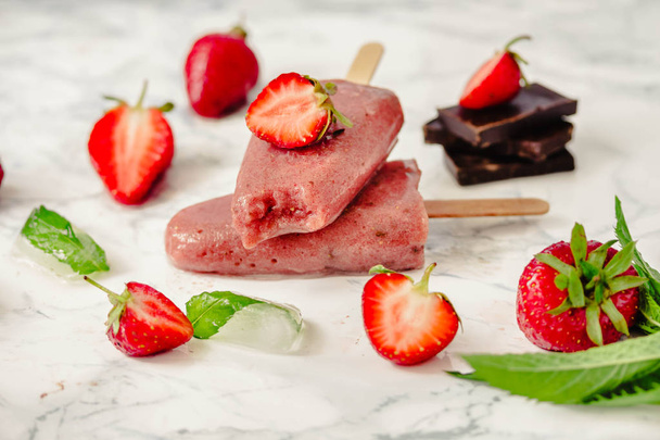 Strawberry ice cream with a banana and chocolate on a stick. Sum - Foto, Bild