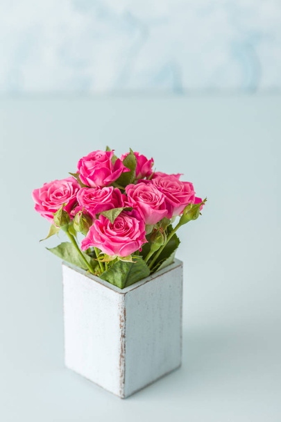 Banner vertical azul pastel con hermoso ramo de rosas rosadas frescas en jarrón retro shabby chic
. - Foto, imagen