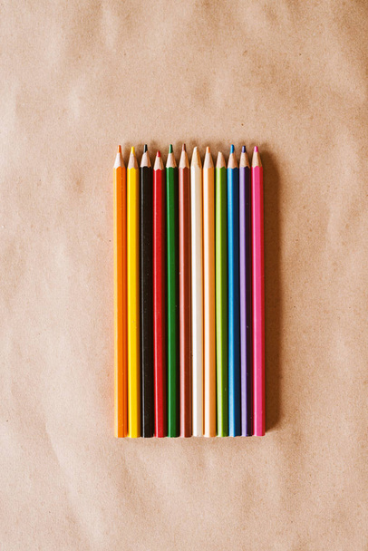 fila de lápices de colores en escritorio de madera
 - Foto, imagen