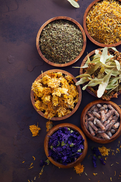Natural alternative herbal medicine of dried herbs and flowers in wooden bowls, selective focus, top view - Photo, Image