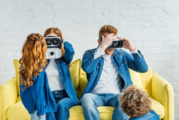 Ebeveynler çocuklarıyla odasında birlikte kanepede otururken 3D gözlük - Fotoğraf, Görsel