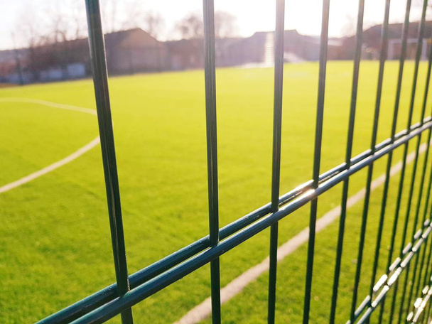 campo de césped para jugar minifootball detrás de la malla de la cerca verde
 - Foto, imagen