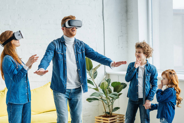 Pais usando óculos VR junto com seus filhos em casa
 - Foto, Imagem