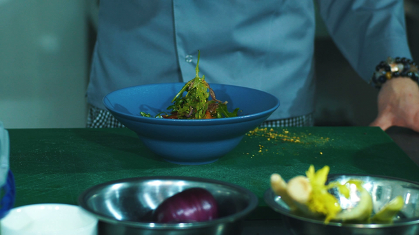 Férfi szakács fűszerek hozzáadása a konyhában, Vértes saláta - Felvétel, videó