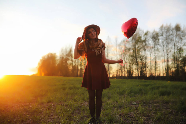 A girl in a hat on a walk in the park. A girl with a basket walk - 写真・画像