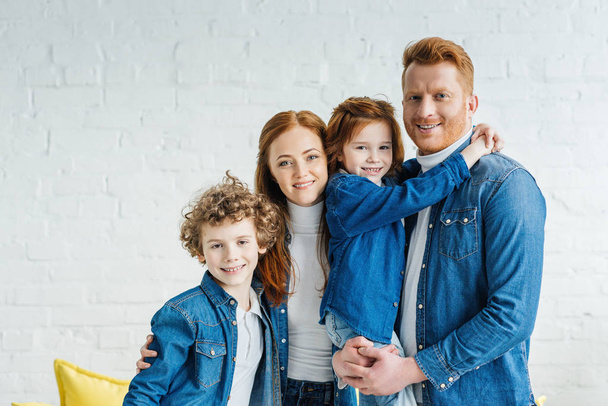 Happy redhead family hugging in light room - Foto, afbeelding