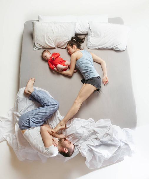 Top view of happy family with one newborn child in bedroom. - Foto, Imagen