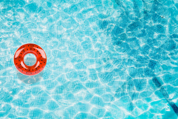 Верхний вид дна бассейна с надувным арбузом и тенью пальмы
 - Фото, изображение