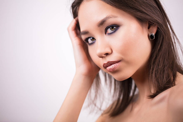 Beautiful woman face portrait. Beauty, skin care concept. Girl with professional makeup on white background, copy space. - Fotó, kép