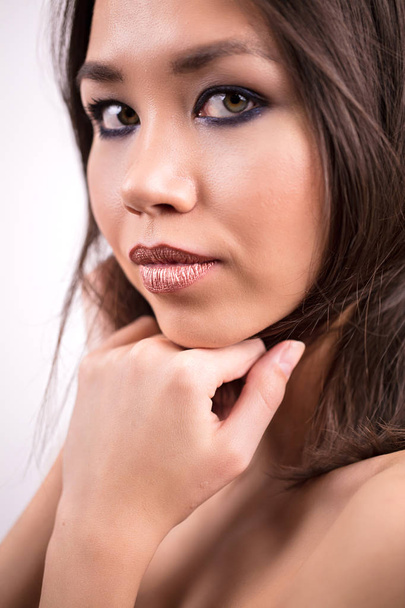 Portrait of a cute woman with a beautiful makeup, close up. The girl looks at the camera. Youth, cosmetics, facial skin care - Fotografie, Obrázek