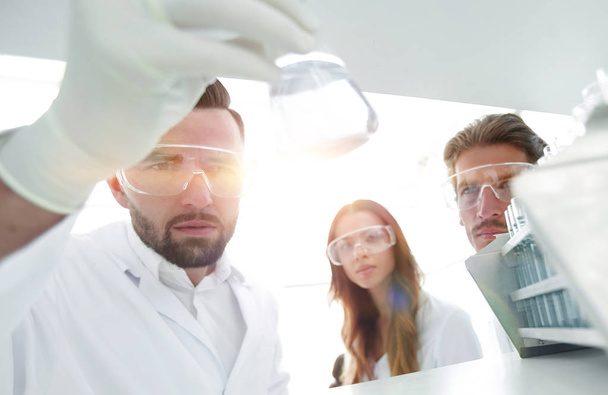 closeup.a group of scientists studying the liquid in the glass t - Fotoğraf, Görsel