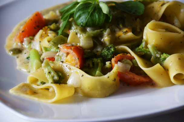 tagliatelle pasta with vegetables, cream-herb sauce, tomatoes - Zdjęcie, obraz