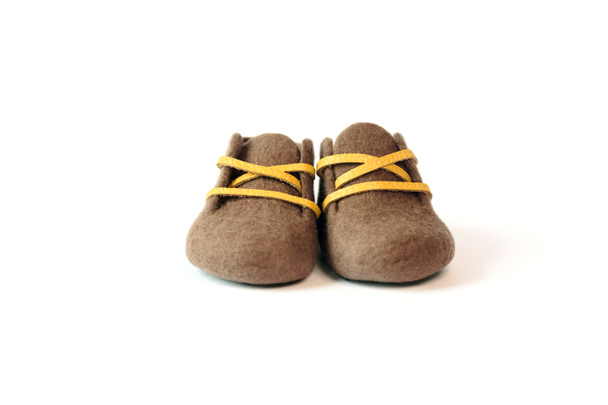 Ręcznie robione buty dziecięce wykonane z wełny merino brązowy na białym tle. - Zdjęcie, obraz